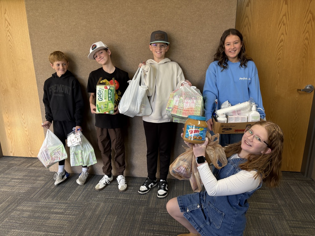 Students posing with food for our food drive