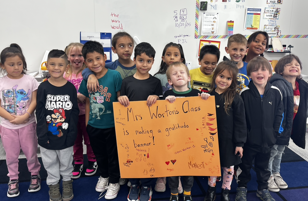 Students holding a poster showing the Unity poster that they created.