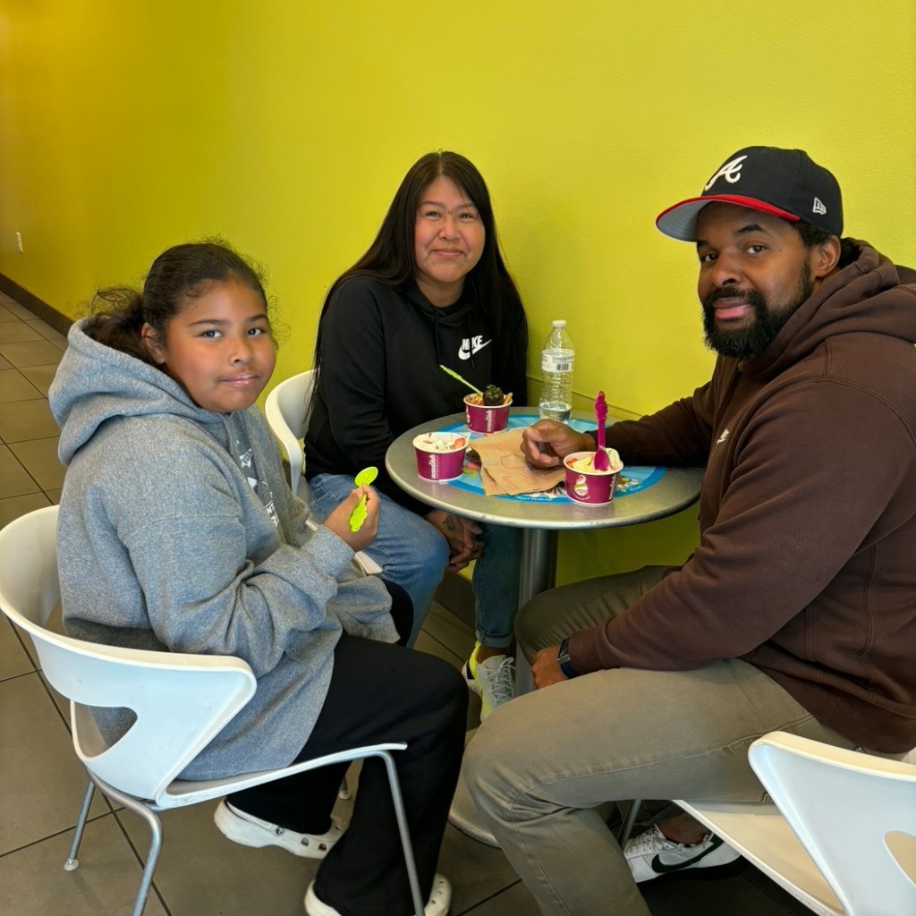 A girl and her parents eating Menchies