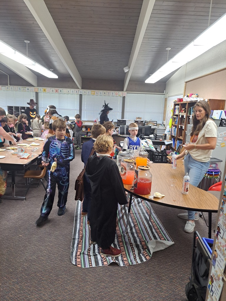 A collection of photos showing elementary students in various Halloween costumes participating in classroom parties. The images include students doing art projects, making snacks, drinking punch, and playing games with their teachers and parent volunteers.