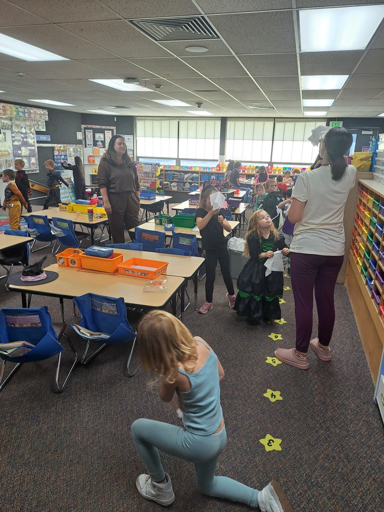 A collection of photos showing elementary students in various Halloween costumes participating in classroom parties. The images include students doing art projects, making snacks, drinking punch, and playing games with their teachers and parent volunteers.