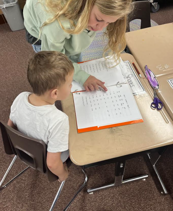 5th grade buddies helping our first graders track their reading and build fluency 