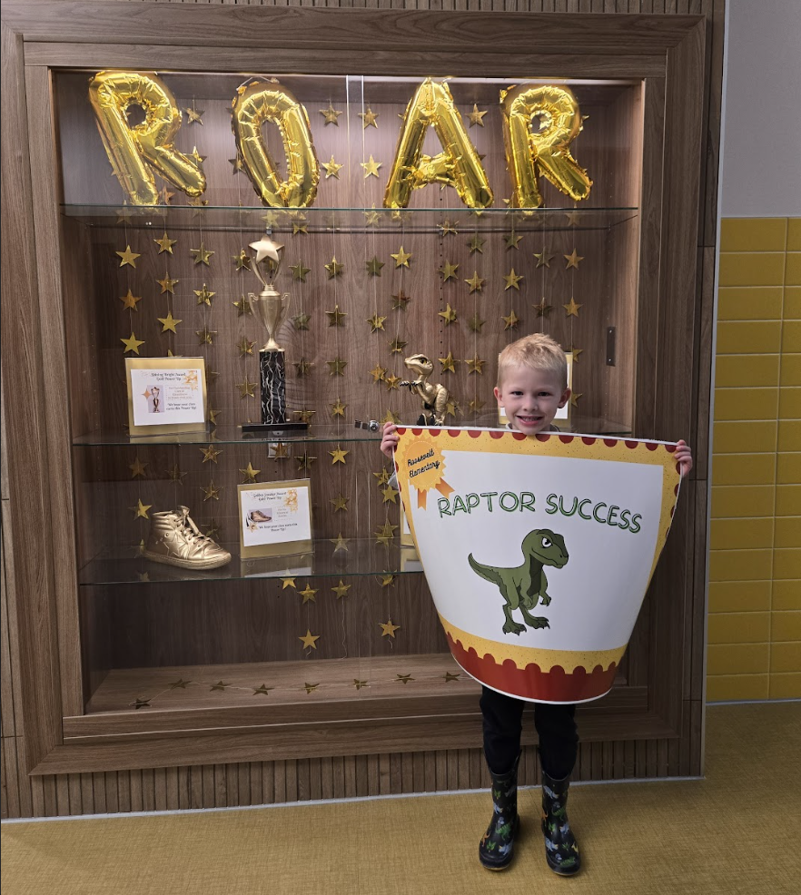 student holding a certificate for the awards they received