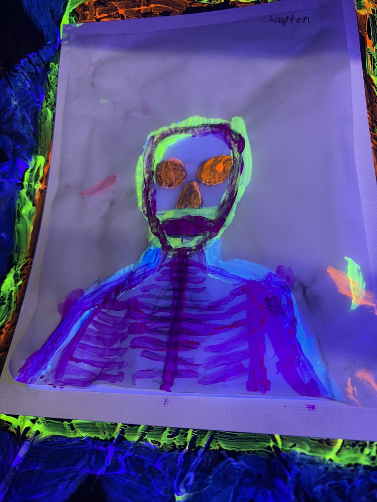 Blacklight Painting- All 2D Art students spent the week in painting in the dark! Art 1 students learned about Dia de los Muertos last week and painting skeleton portraits using colors and symbols that represent themselves and their ancestors. Art 2 students used different colors to draw each other in poses and gestures focusing on value with the different colors. Finally, Art 3 students practiced making their first mural by making an ofrenda that students could hang their completed skeletons on. 