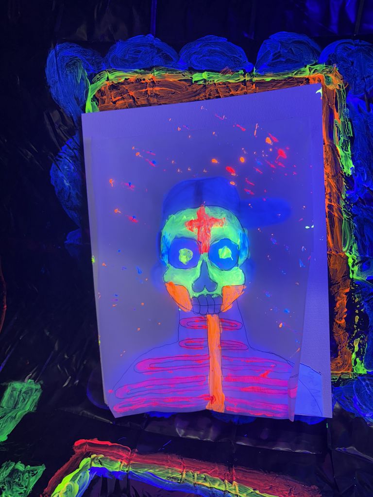 Blacklight Painting- All 2D Art students spent the week in painting in the dark! Art 1 students learned about Dia de los Muertos last week and painting skeleton portraits using colors and symbols that represent themselves and their ancestors. Art 2 students used different colors to draw each other in poses and gestures focusing on value with the different colors. Finally, Art 3 students practiced making their first mural by making an ofrenda that students could hang their completed skeletons on. 