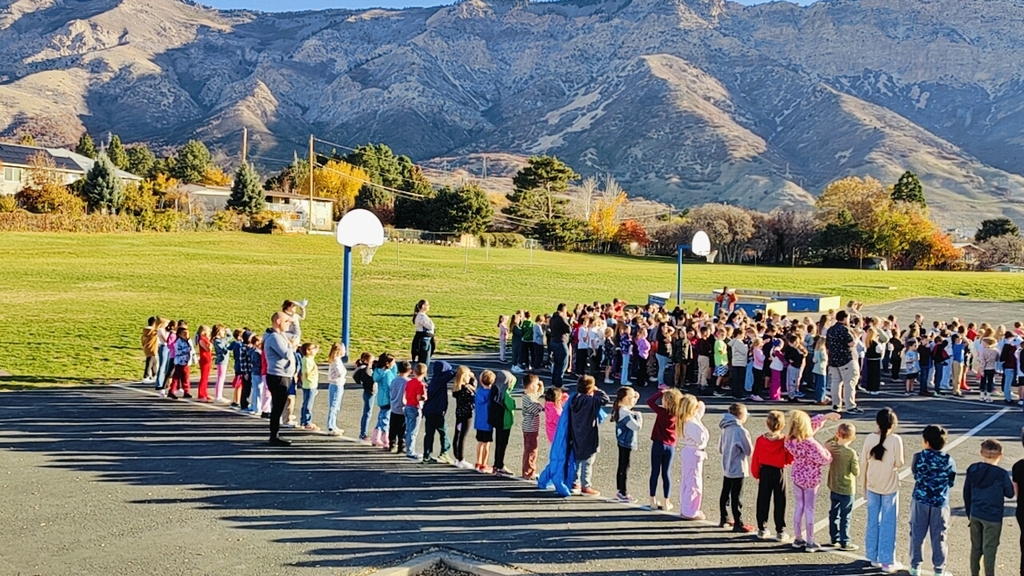 The students of Bates Elementary looking up to the flag in Cold Water Canyon while saying The Pledge of Allegiance.