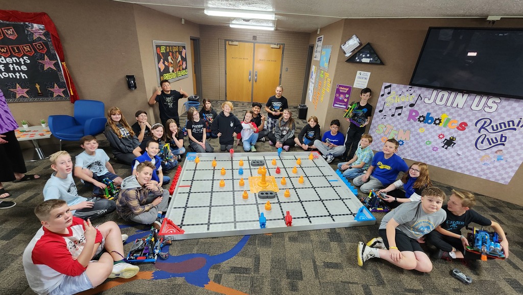 Robotics Club Members gathered around field and posing for camera
