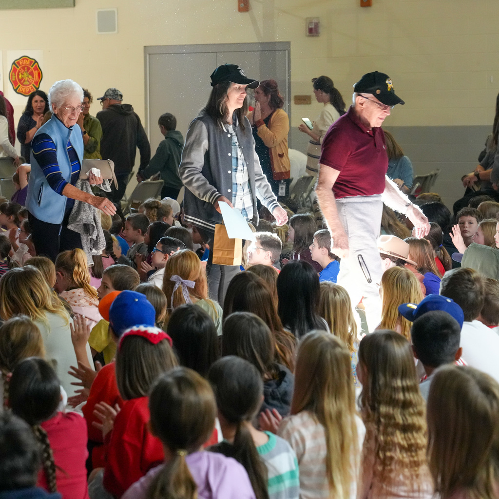 Veterans and active service members walking through the students during the veterans parade.