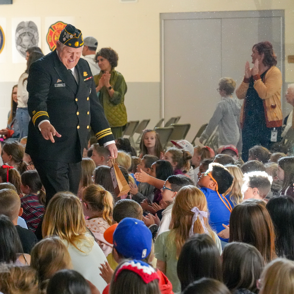 Veterans and active service members walking through the students during the veterans parade.