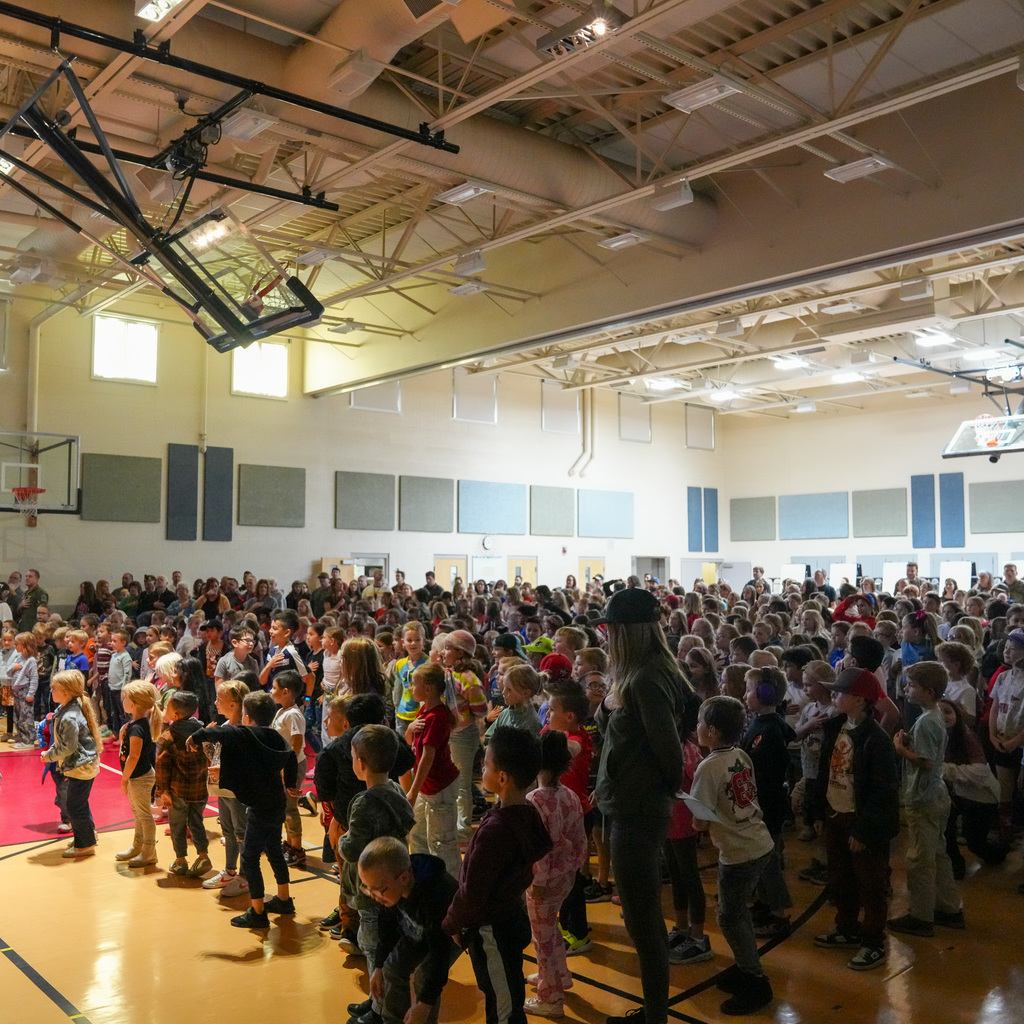 Students standing and saying the pledge of alligence with their hands over their hearts.