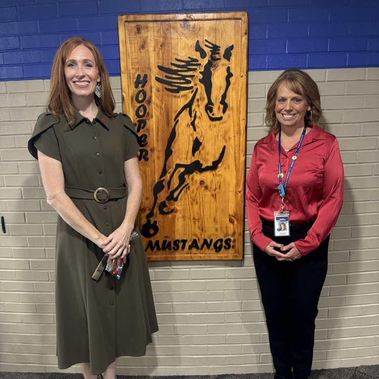 Mrs Taylor and Mrs breeding standing by hooper mustangs sign