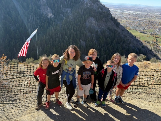 Mrs. Allen with some of her students at the top of Coldwater Canyon in front of the Major flag.