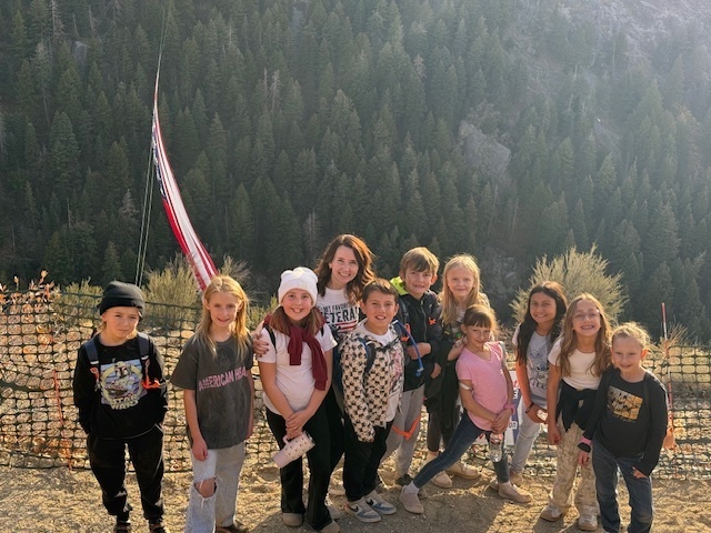 Mrs. Allen with some of her students in front of The Major Flag at the top of Cold Water Canyon