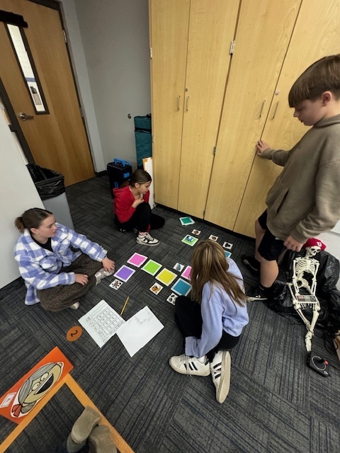 kids sitting on the floor gathered around colorful cards