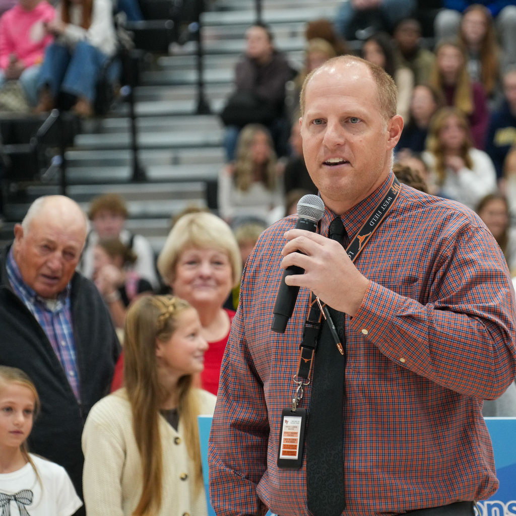 Mr. Martini in front of student assembly