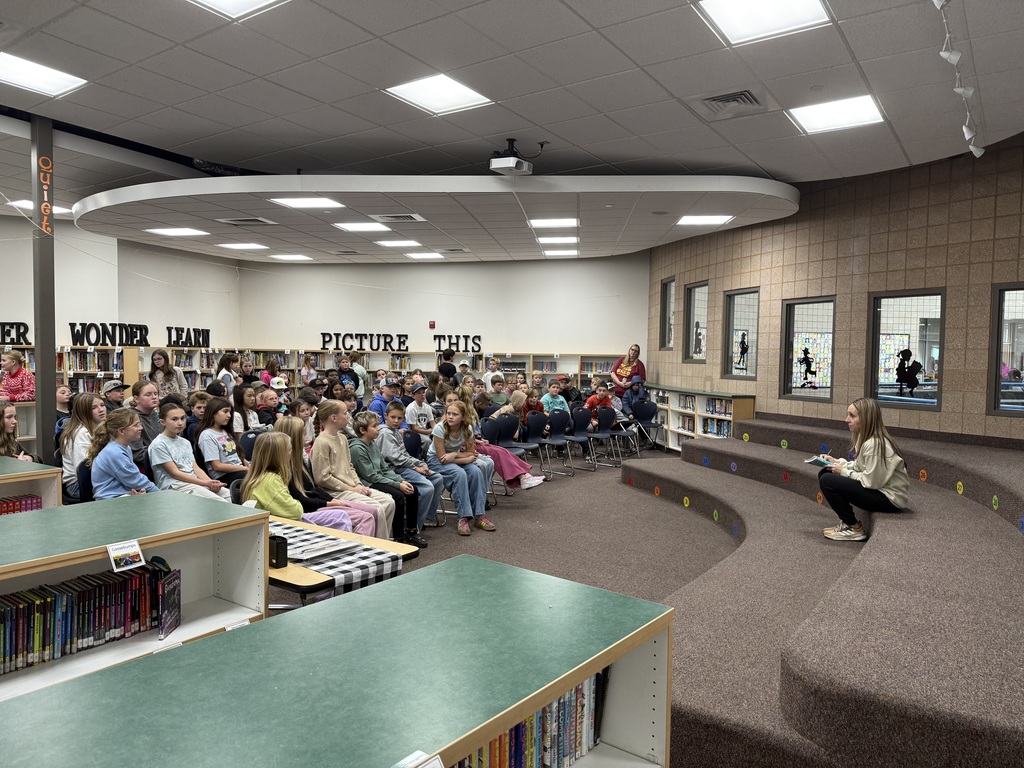 Group of students sitting in the library looking at Mrs. Simonsen.