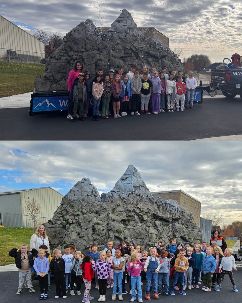 Student classes are gathered outside, standing in front of the mountain display, smiling and posing with their teachers.