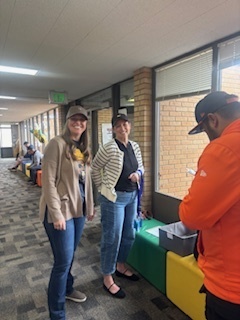 This is a picture of two PTA Members signing in a Dad to participate in Rad Dads.