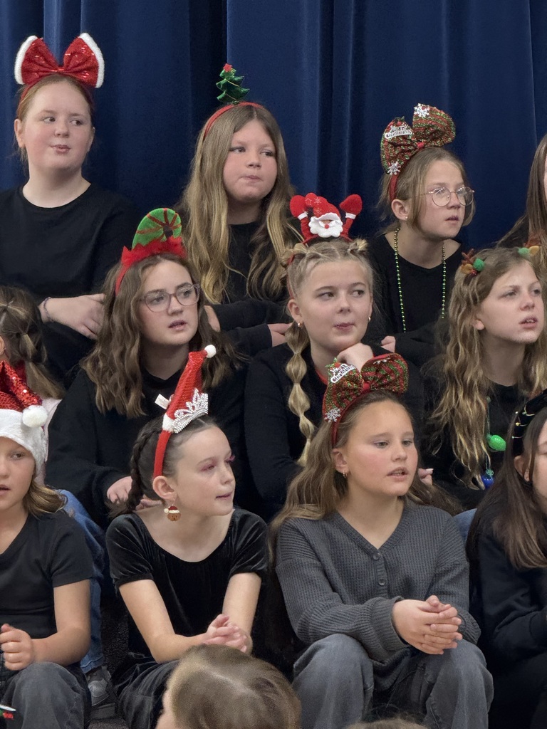 choir students singing wearing festive headbands