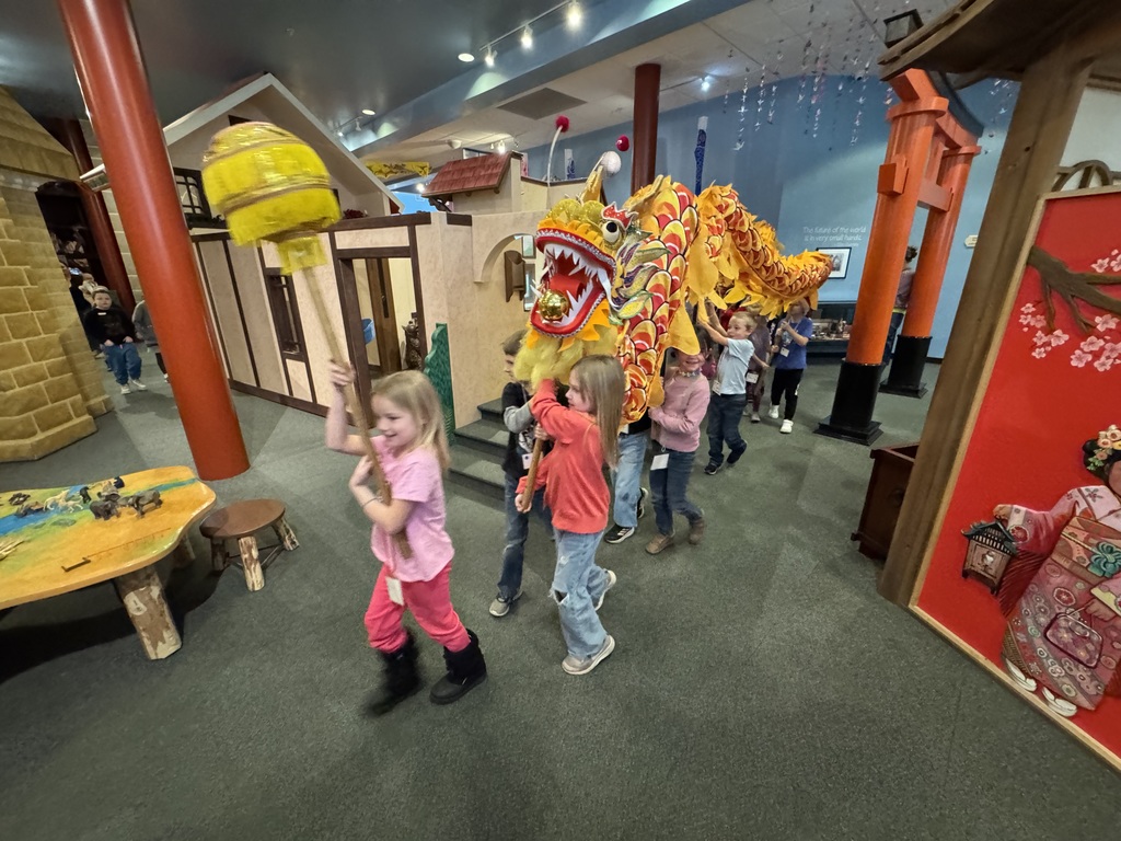 group of students moving a dragon puppet together