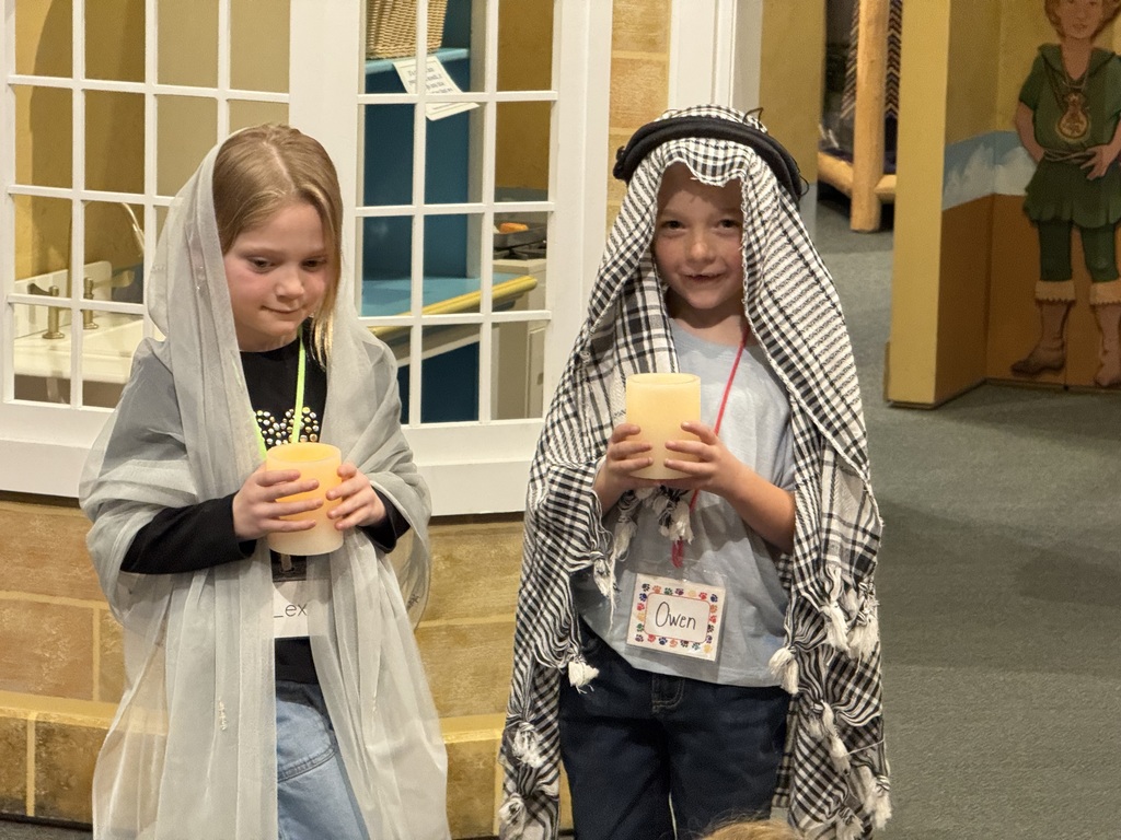 group of students wearing costumes and holding candles