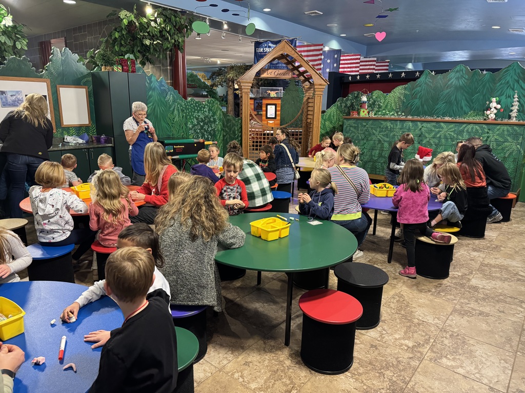 group of students sitting at tables and looking at a presenter