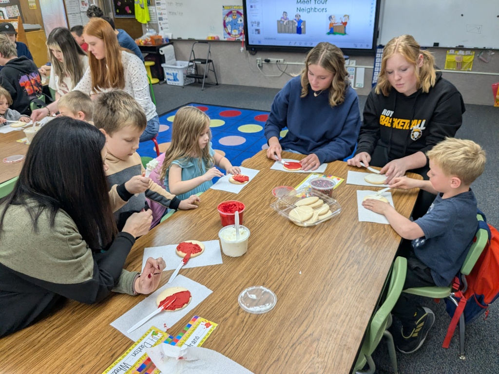 Roy Jr. High students helping kindergarteners decorate cookies