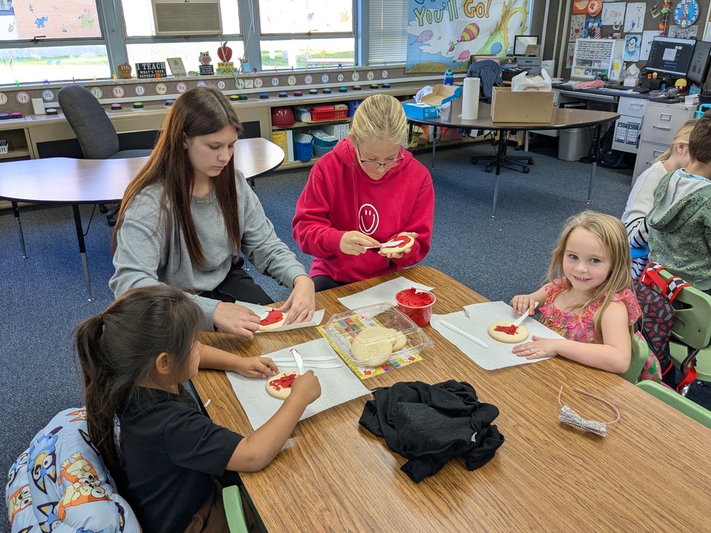Roy Jr. High students helping kindergarteners decorate cookies