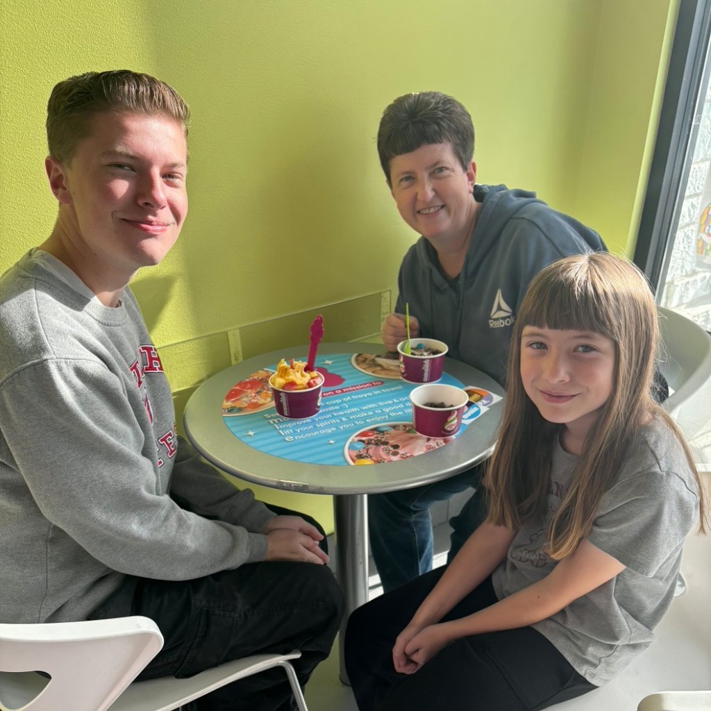 A girl and her parents eating icecream at Menchies