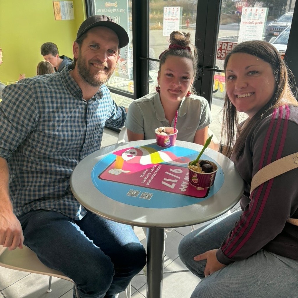 A girl and her parents eating icecream at Menchies