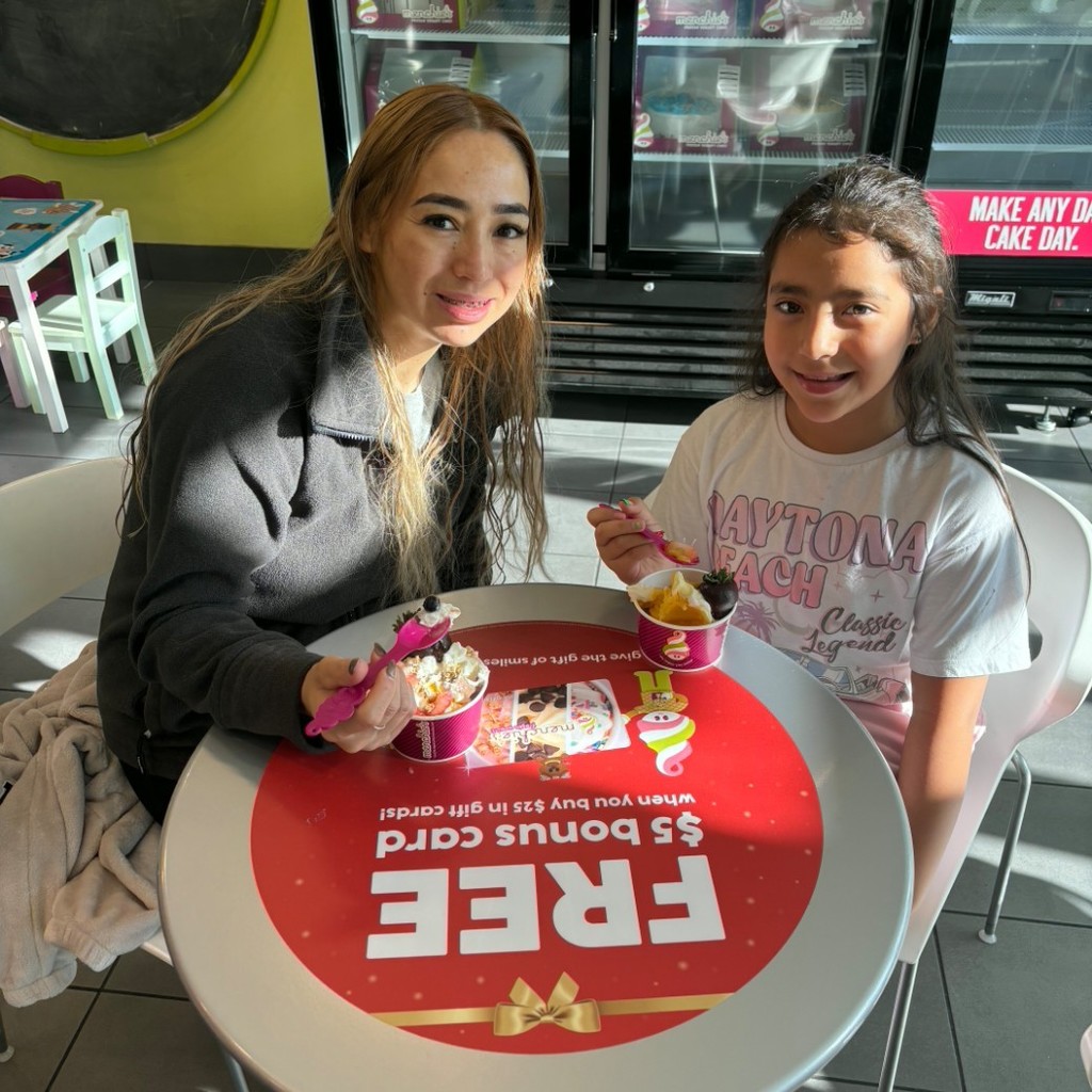 A mom and her daughter eating icecream at Menchies