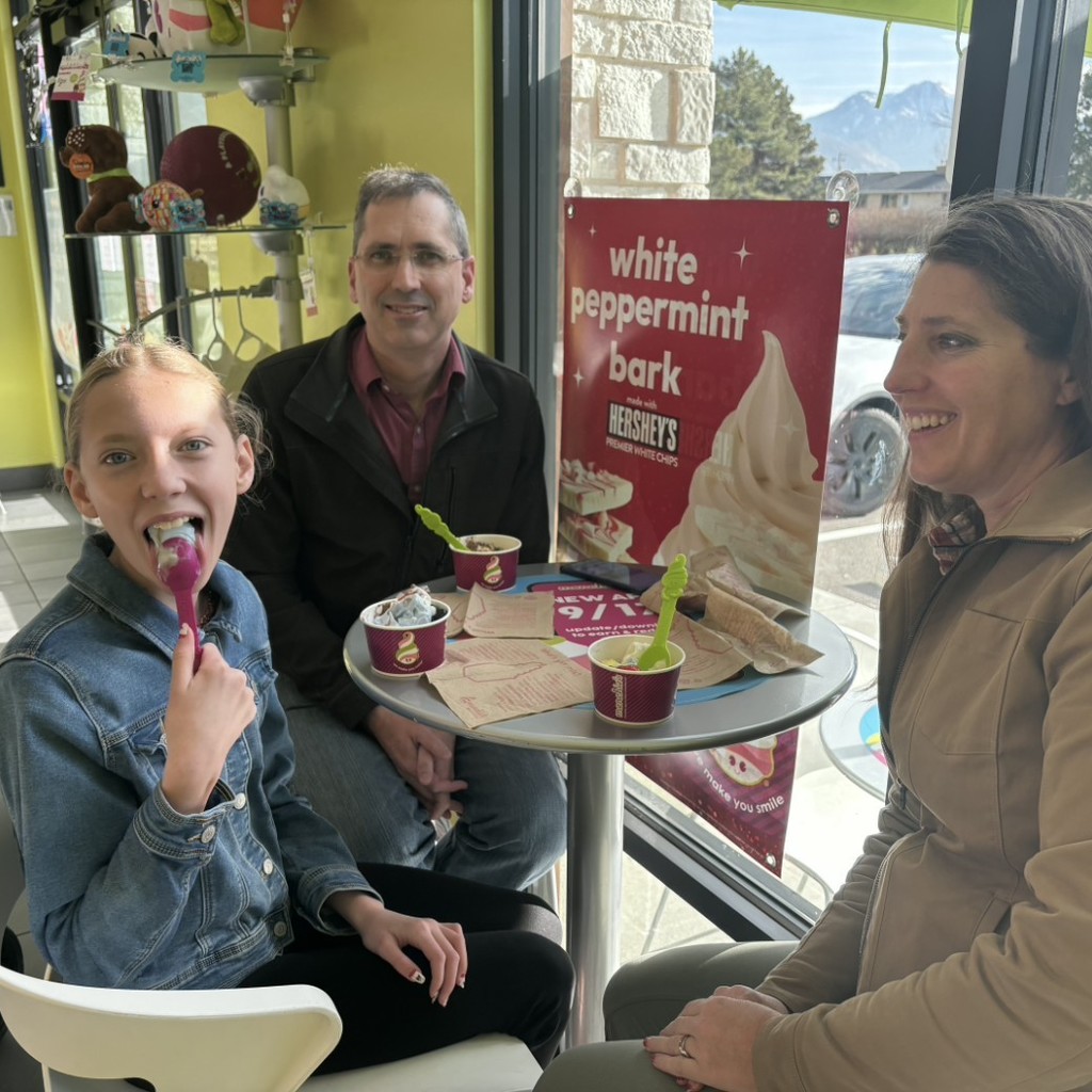 A girl and her parents eating icecream at Menchies