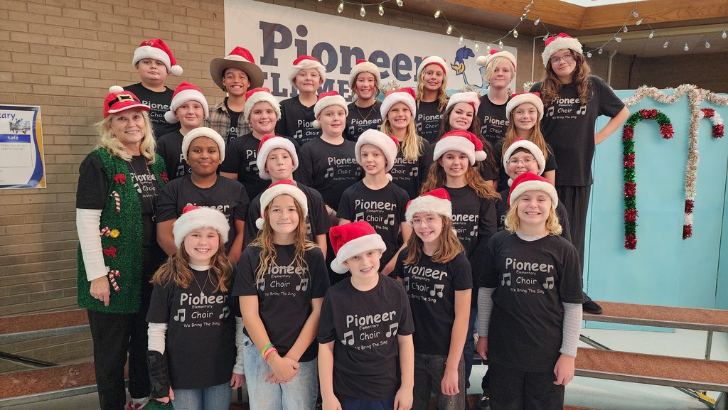 Choir students wearing santa hats posing for camera 