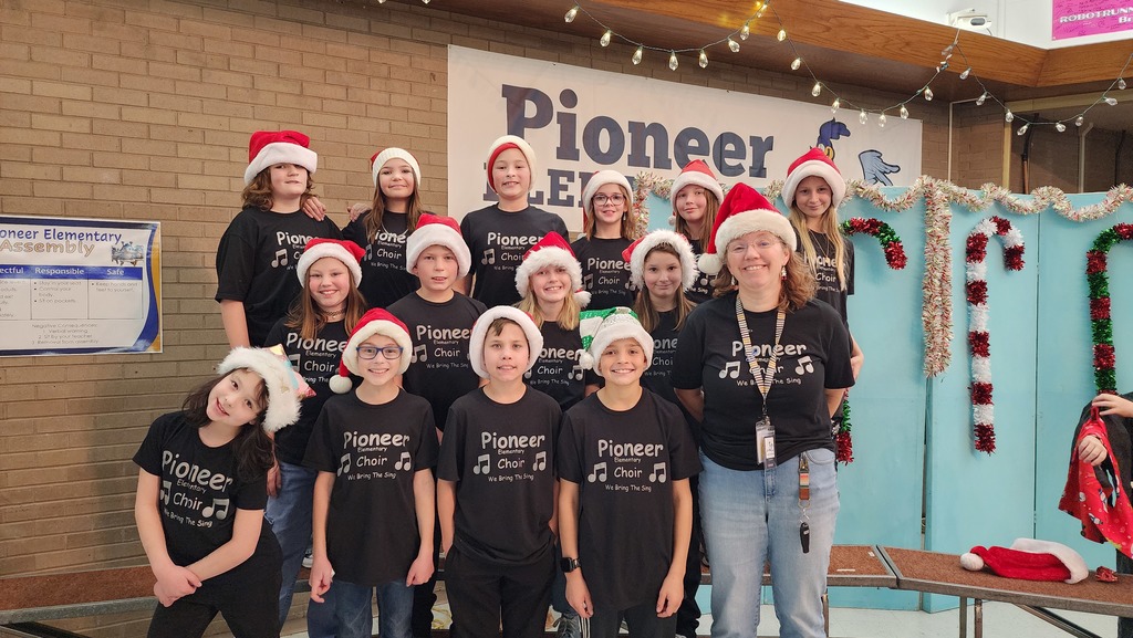 Choir students wearing santa hats posing for camera