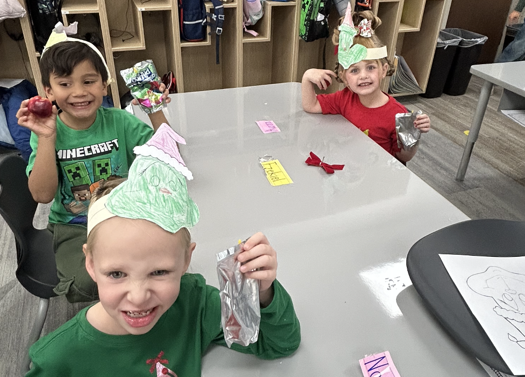 students celebrating grinch day with student made grinch hats