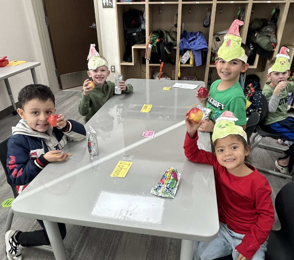 students celebrating grinch day with student made grinch hats