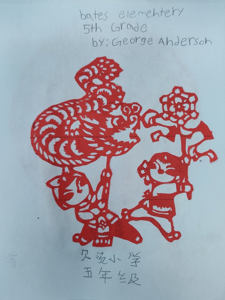 fifth grade paper cutting of a dragon and girl done with red paper.