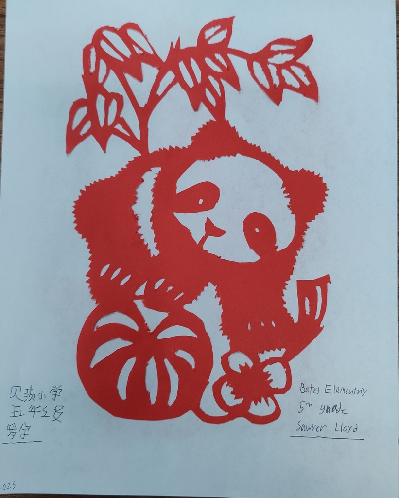 Paper cutting  done by a 5th grader with red paper.  The image created is of a panda with a tree and ball.  