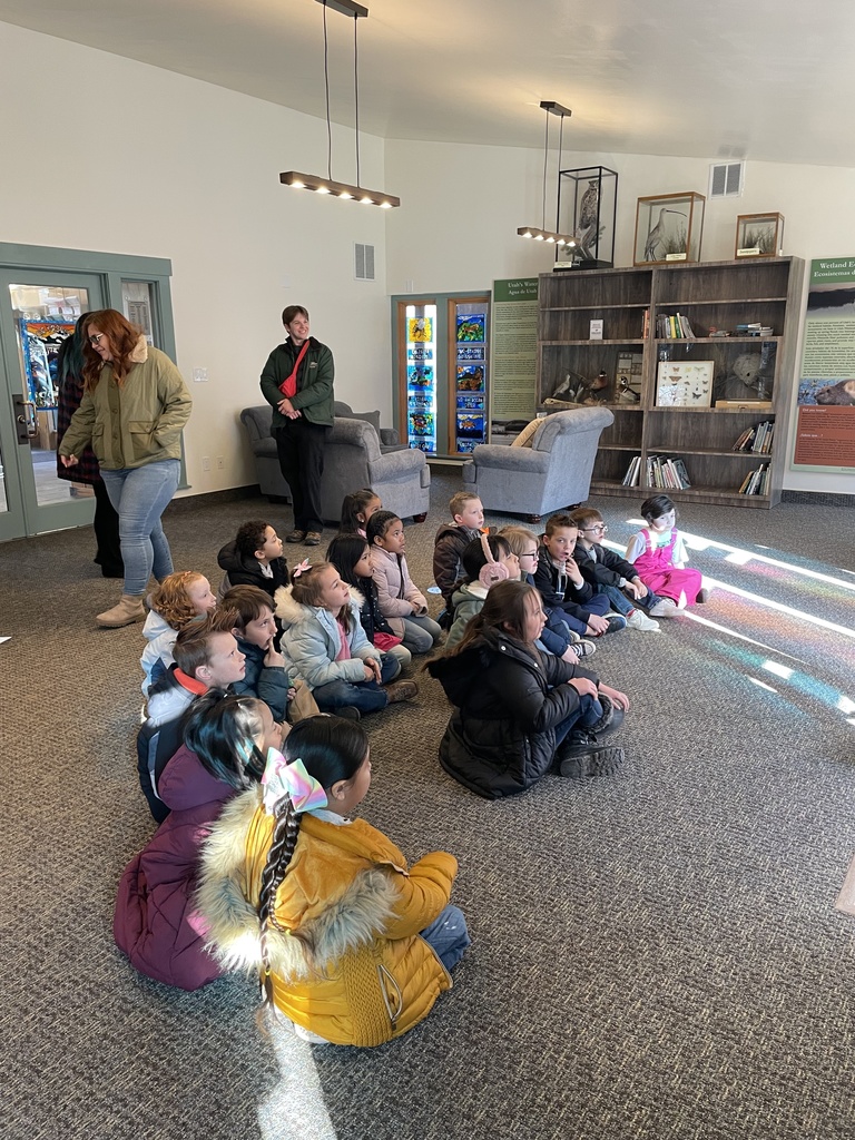 first grade students listening to a presenter