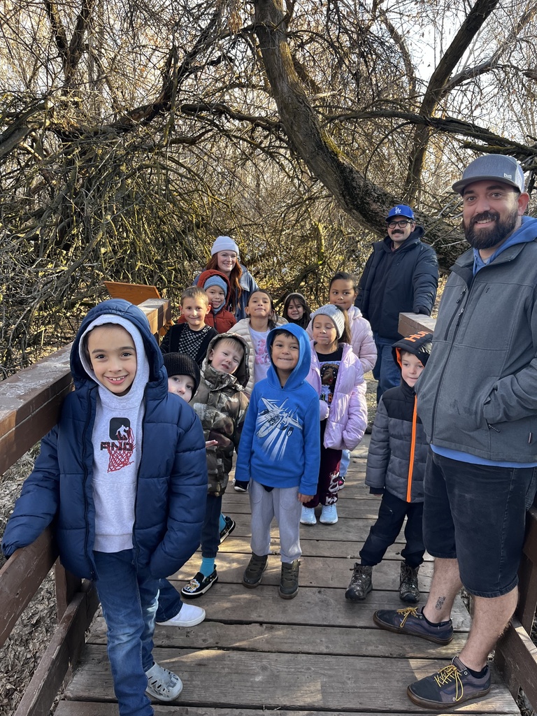 first grade class posing on a bridge