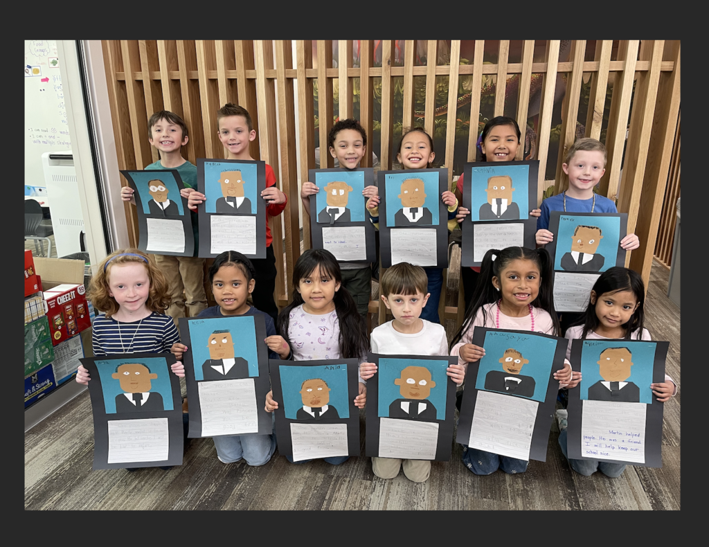 first grade students holding up their martin luther king jr art