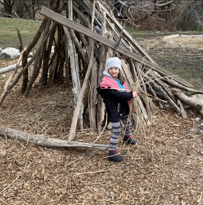 Student by a wooden structure. 