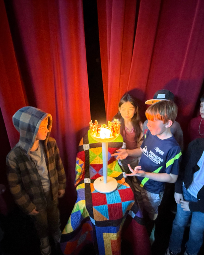 Small group of students looking at a "torch" that starts OSE version of the Olympics. 