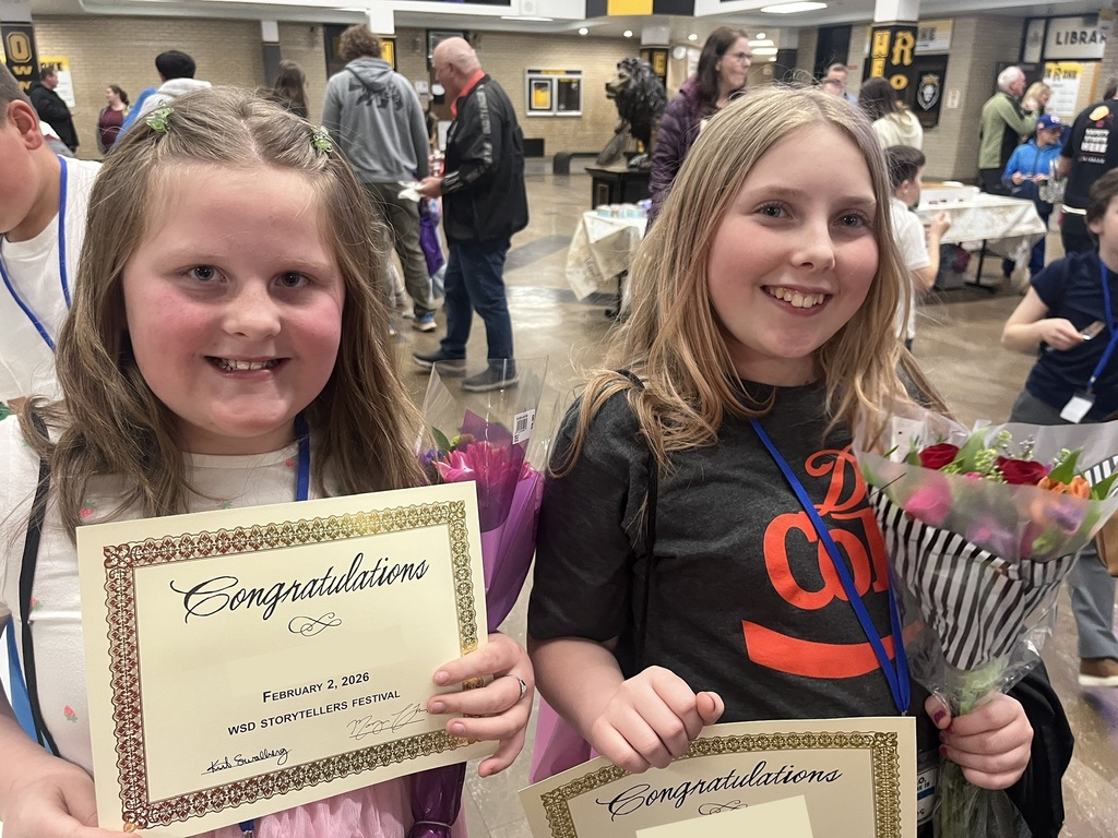 two female students holding their awards and flowers