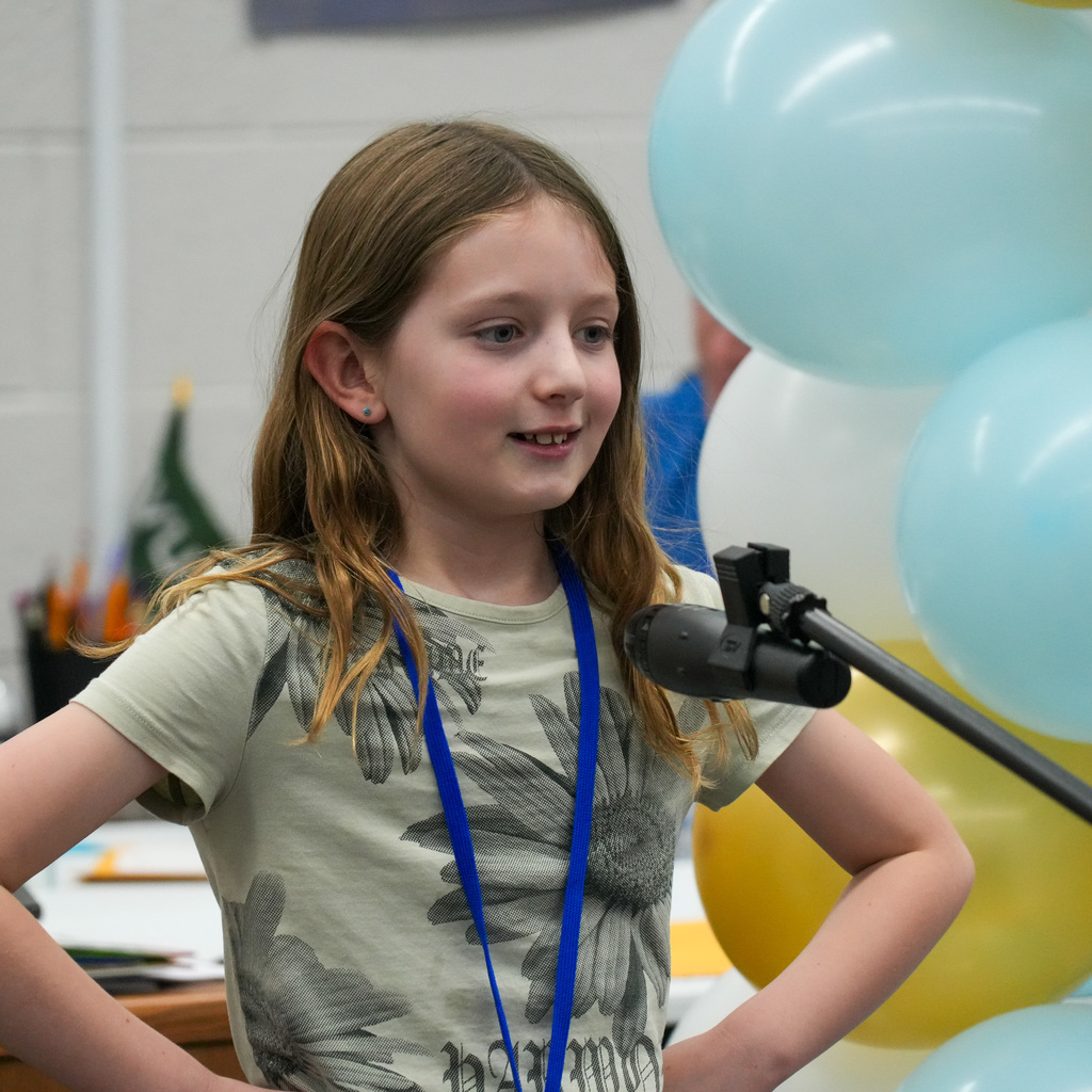 Students telling stories at a microphone.