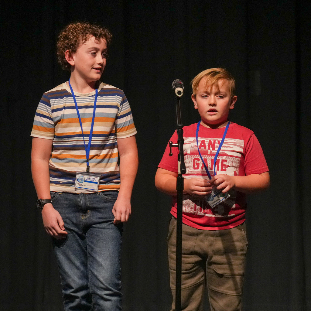 Students telling stories at a microphone.