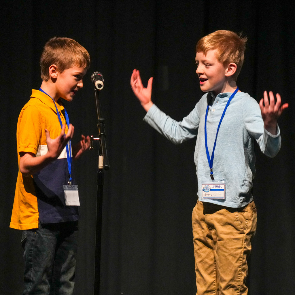 Students telling stories at a microphone.