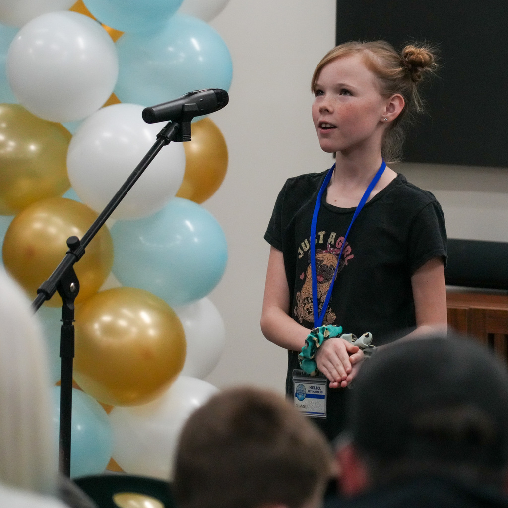 Students telling stories at a microphone.
