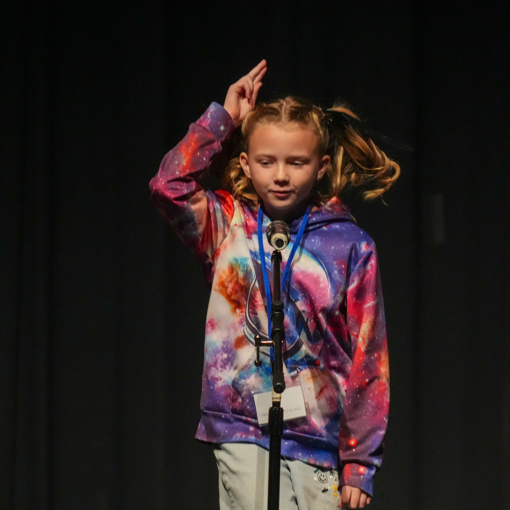 Students telling stories at a microphone.