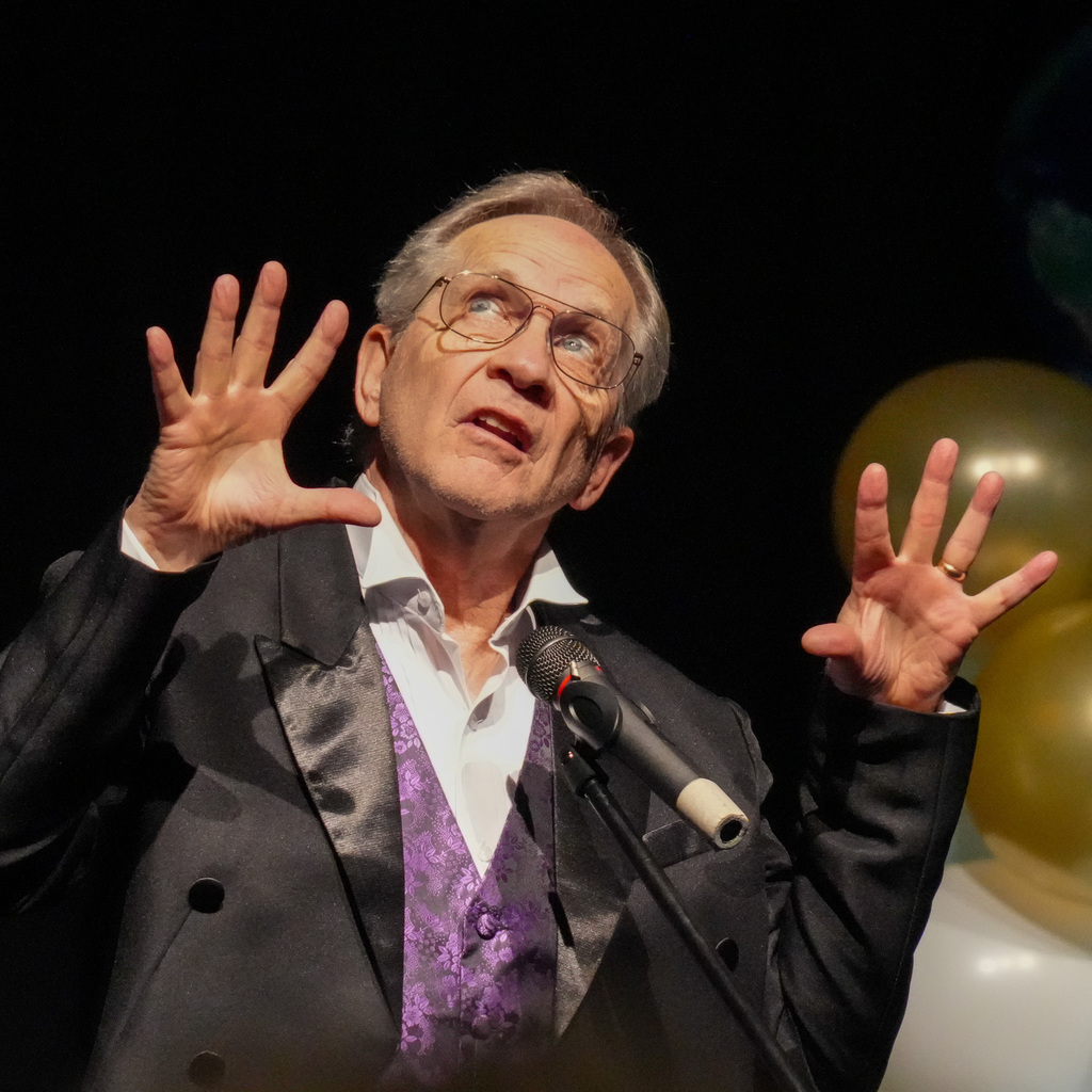 Adult telling stories at a microphone.